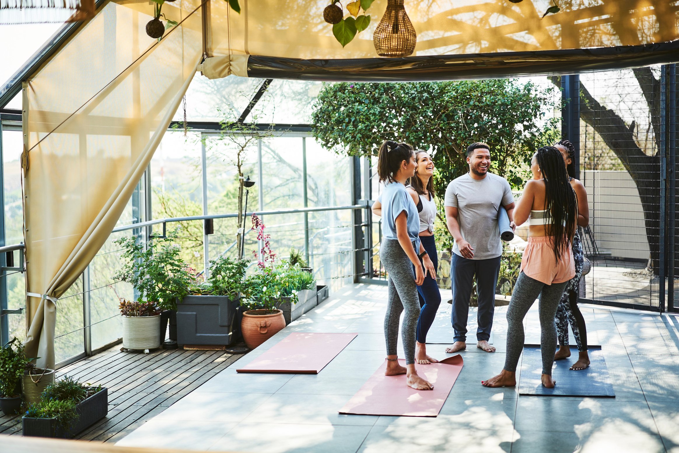 Happy fit friends communicating after yoga class